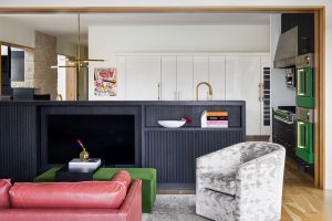 Custom home sitting area next to kitchen with wood flooring and black accents