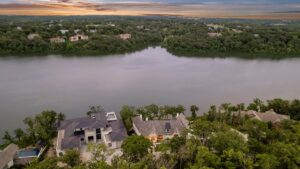 Zoomed out view of custom built Belton MO home and surrounding land including lake