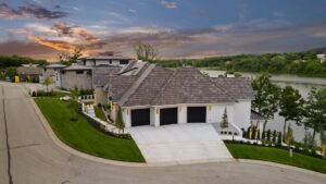 View of 3 car garage and driveway of custom built Belton MO home