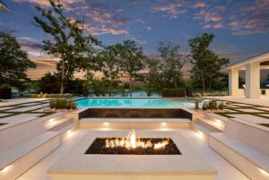 View of outside pool deck and fireplace at custom built Belton MO home